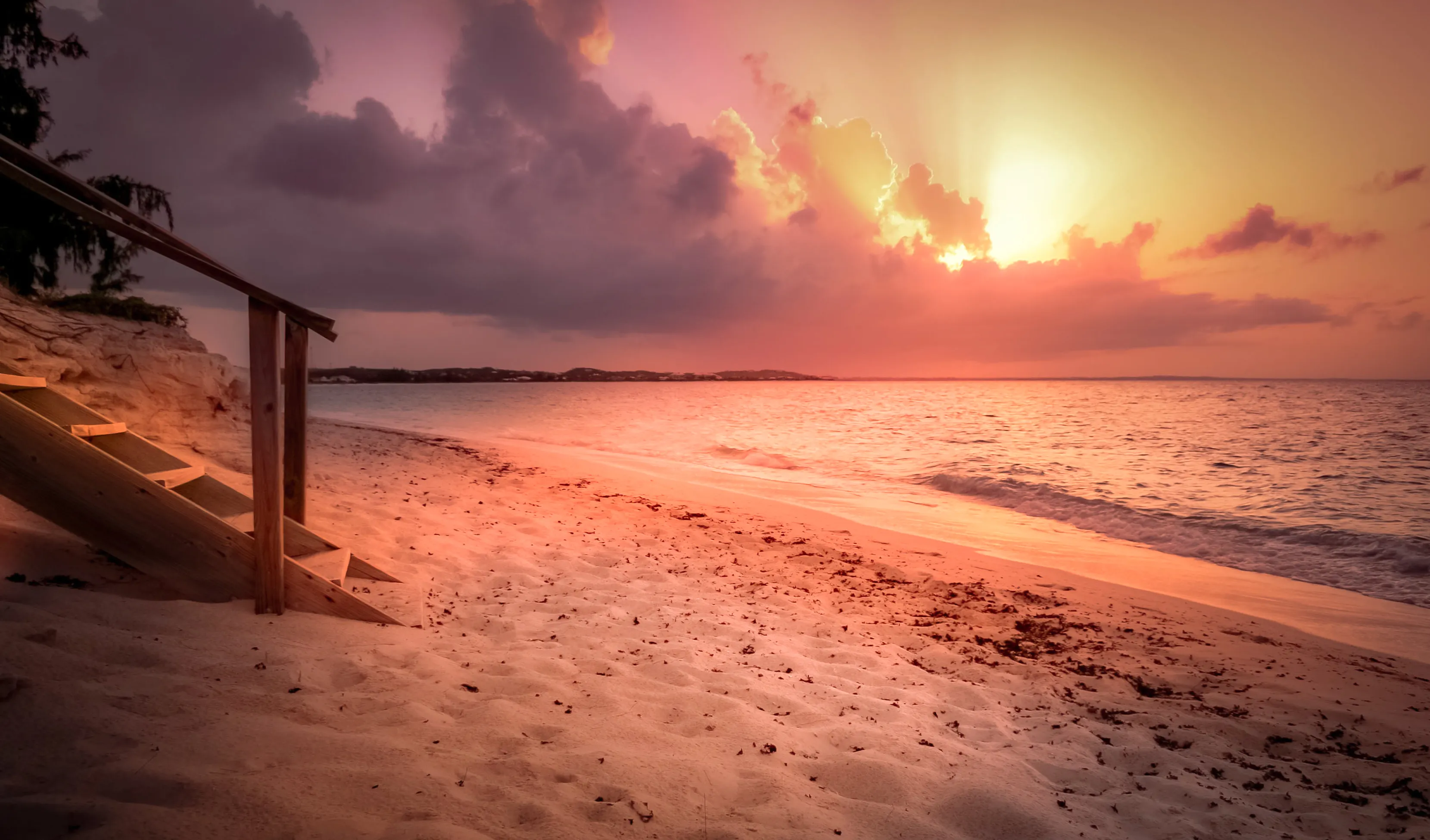 Sunset glowing over the calm water and soft sand of Grace Bay in Turks and Caicos