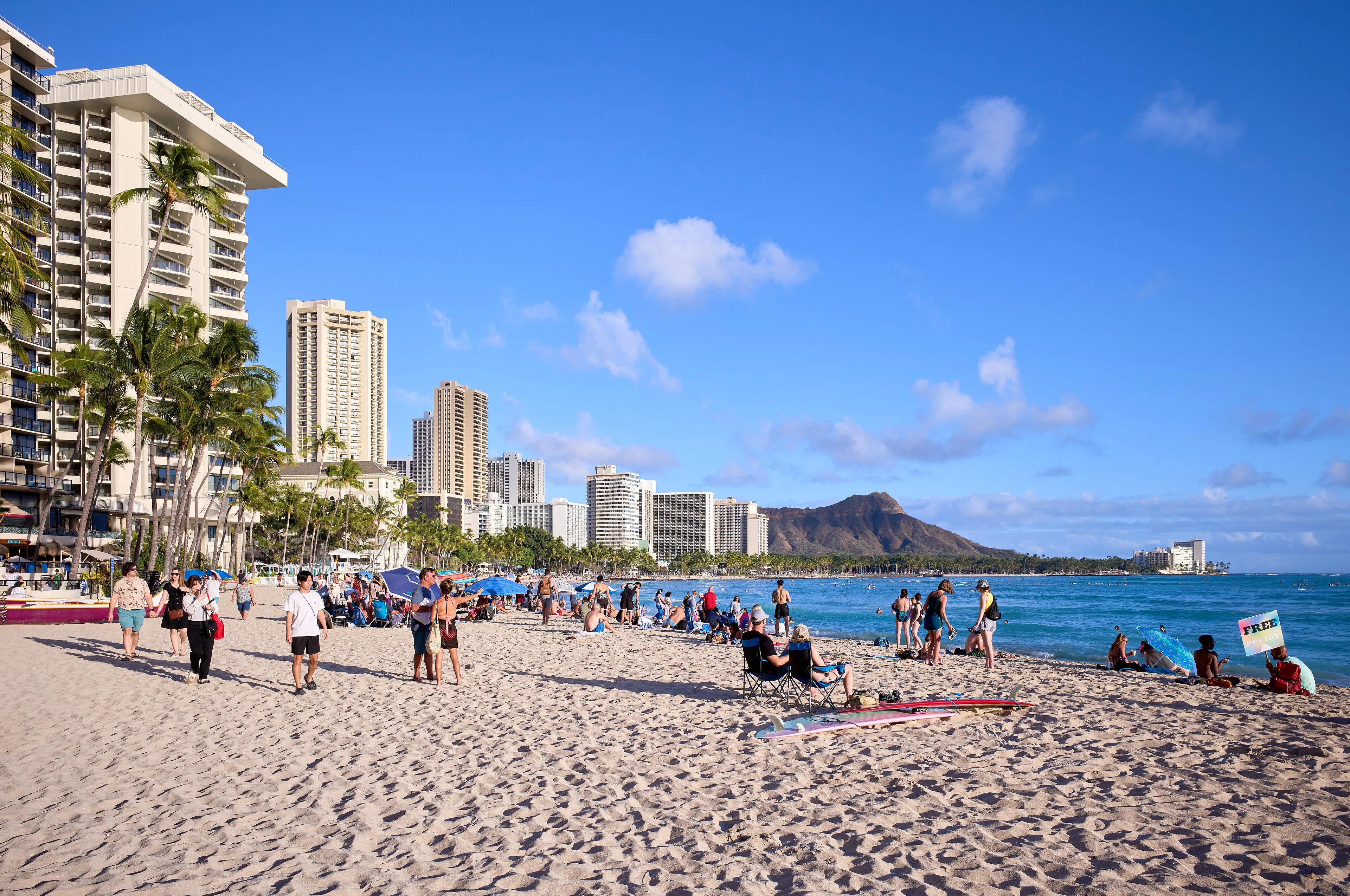 Waikiki Beach on Oahu, lined with palms and hotels, with Diamond Head beyond