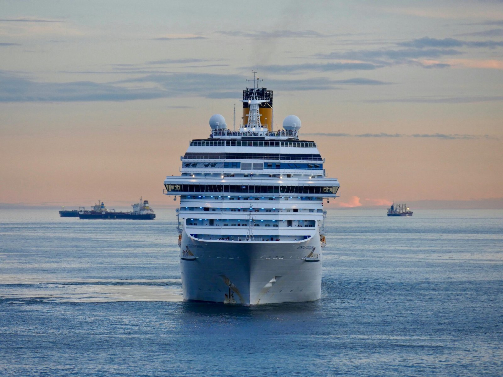 A grand cruise ship sailing at sunset on a serene ocean, evokes travel and adventure.